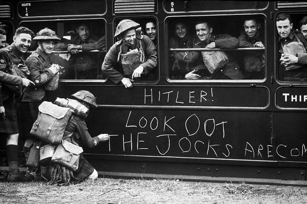 A solider of the Cameron Highlanders chalks a warning to Hitler 