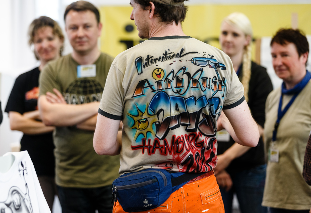 teacher of the T-shirt workshop wears a self made shirt during the International Airbrush Days