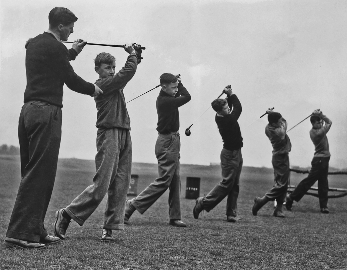 Five young men being taught how to play golf by an instructor circa 1950. 