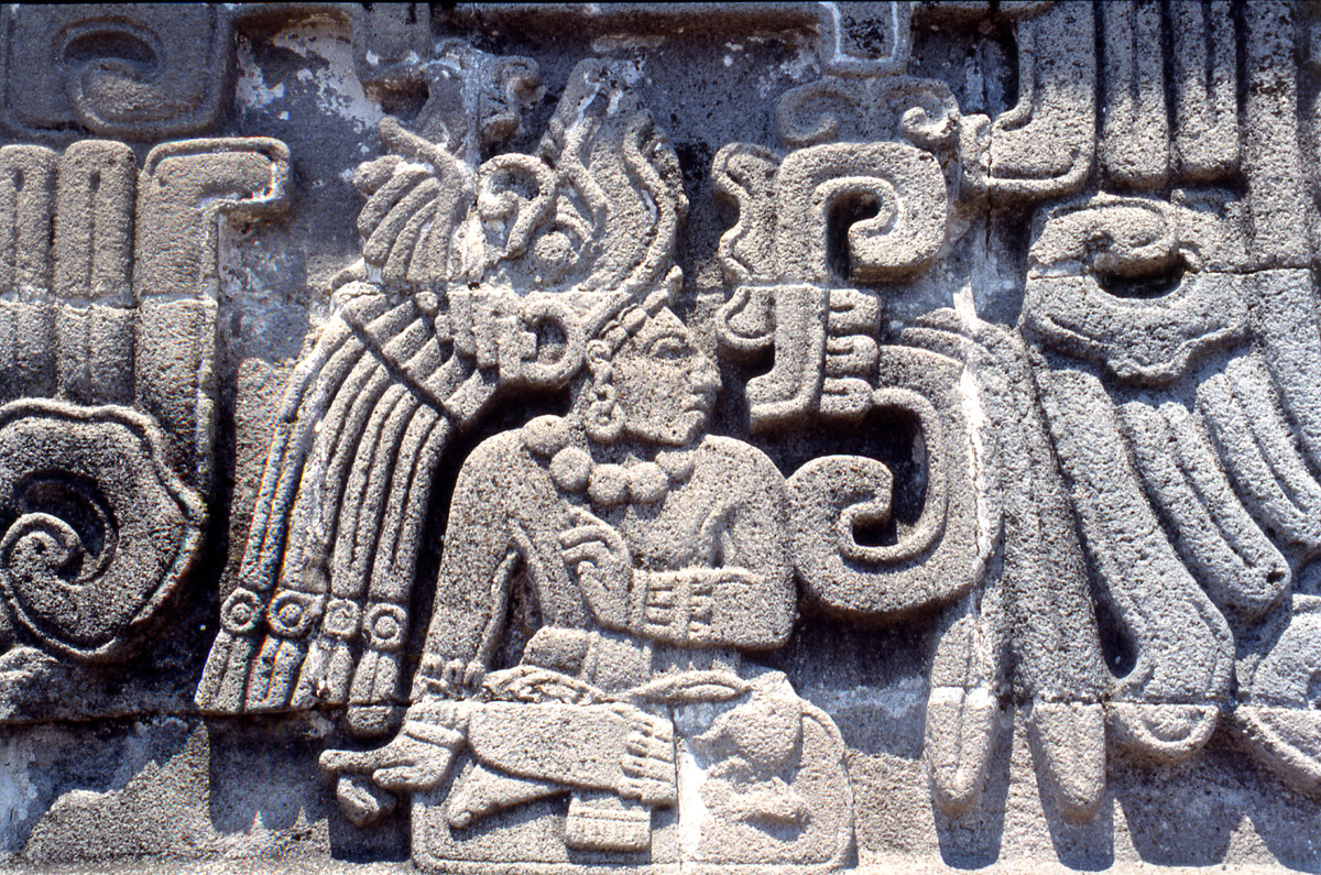Detail from the Temple of the Feathered Serpent at Xochicalco, showing a richly attired personage, so called 9 Wind (the birthdate of the god Quetzalcoatl Feathered Serpent), The style owes much to lowland Classic Maya representations of seated rulers