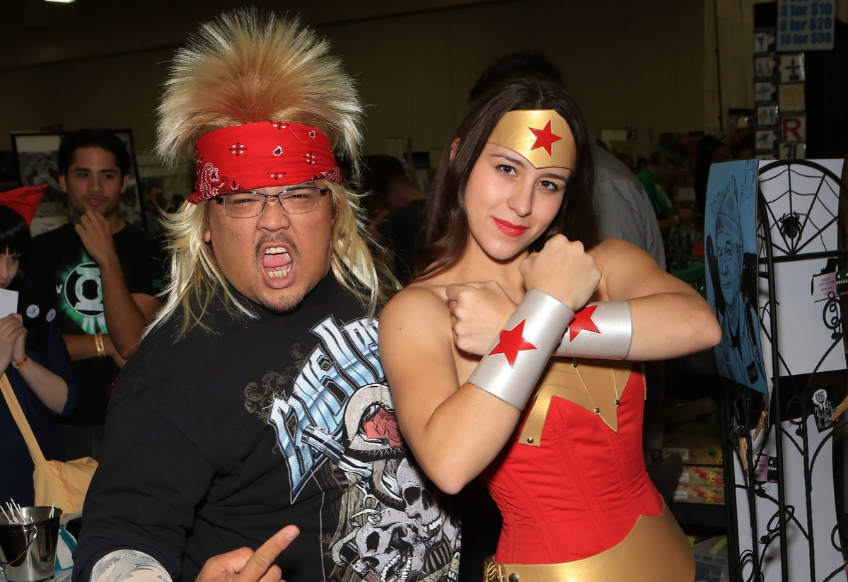 Free Isabelo, dressed as a 1980's rocker character and Sarah Paige, dressed as the character Wonder Woman from the 
