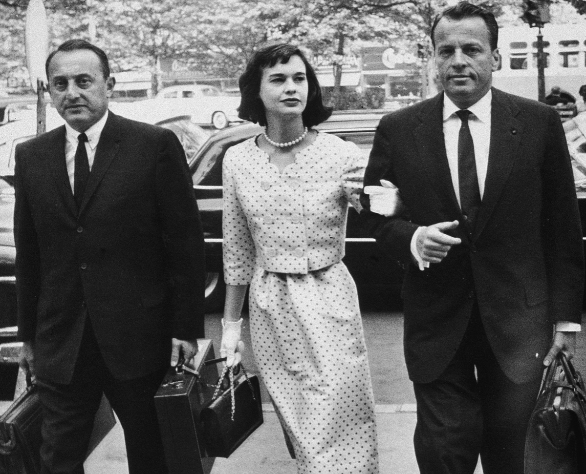 American heiress and socialite Gloria Vanderbilt walks with her attorneys on the way to a custody hearing with her former husband, Leopold Stokowski, June 5, 1959.