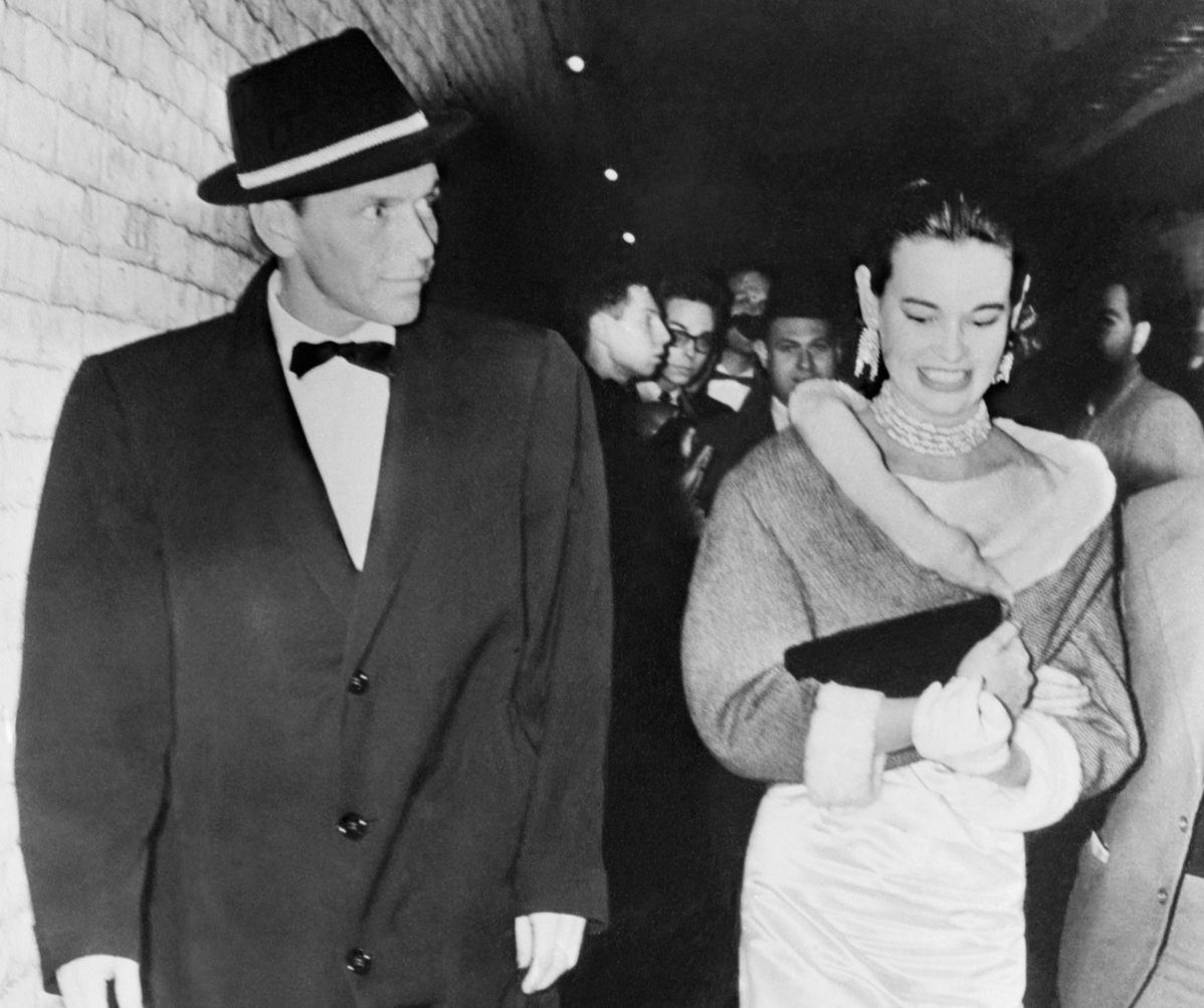 Heiress actress Gloria Vanderbilt goes backstage with her escort singer Frank Sinatra, to congratulate the players at the opening of the musical 