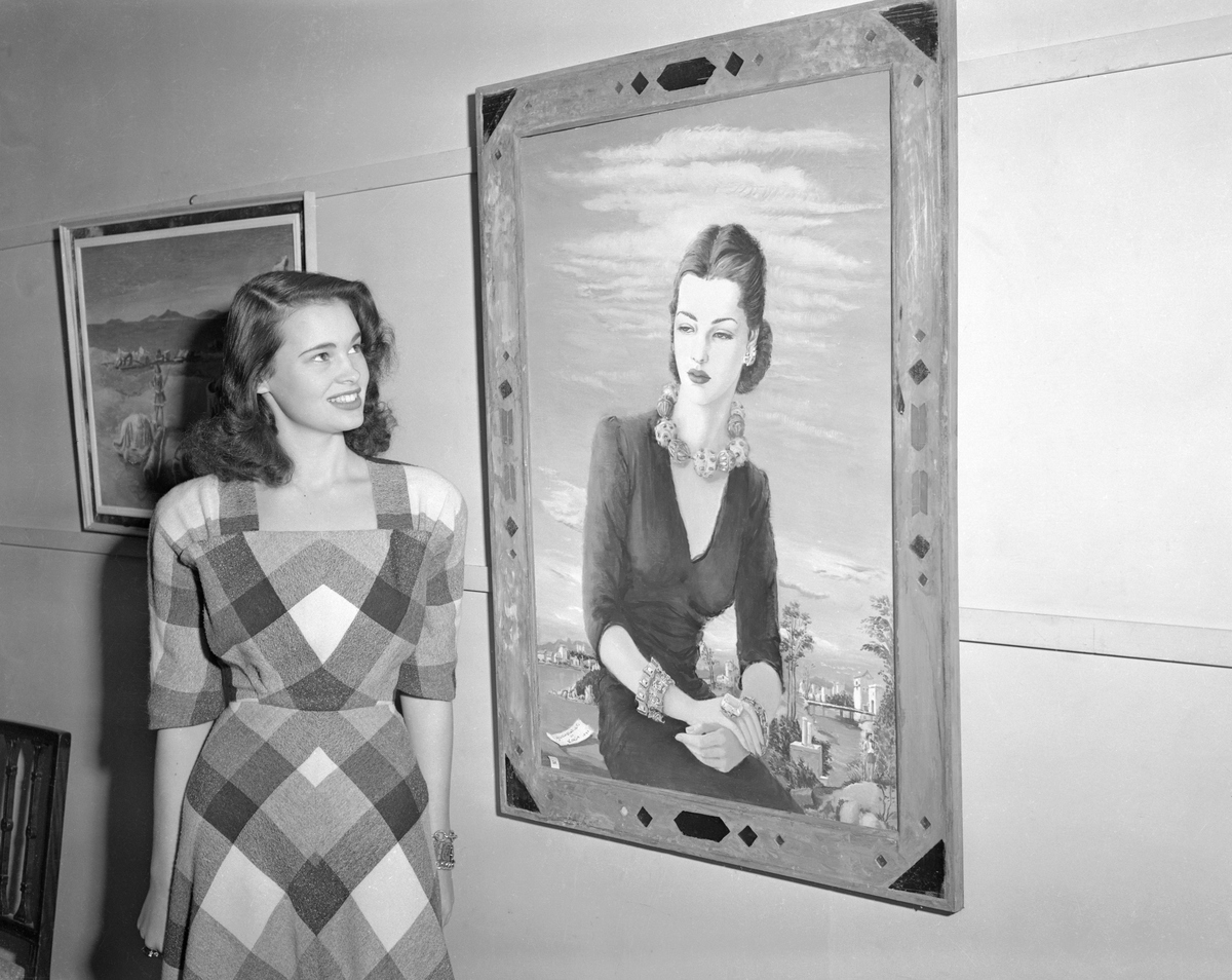 Gloria Vanderbilt stands beside her portrait painted by Miss Karin Van Leyden