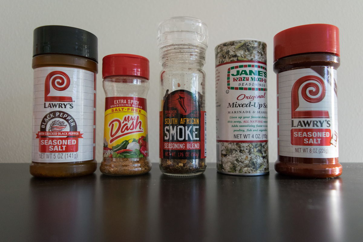 A variety of jars of seasonings in a row including Mrs Dash second from the left