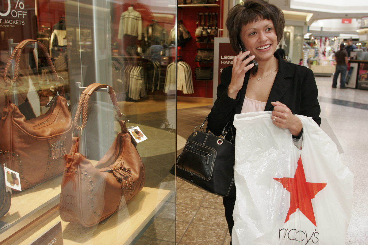 A woman talking on a cell phone holding a Macy's bag at Westfield Shoppingtown Southlake.