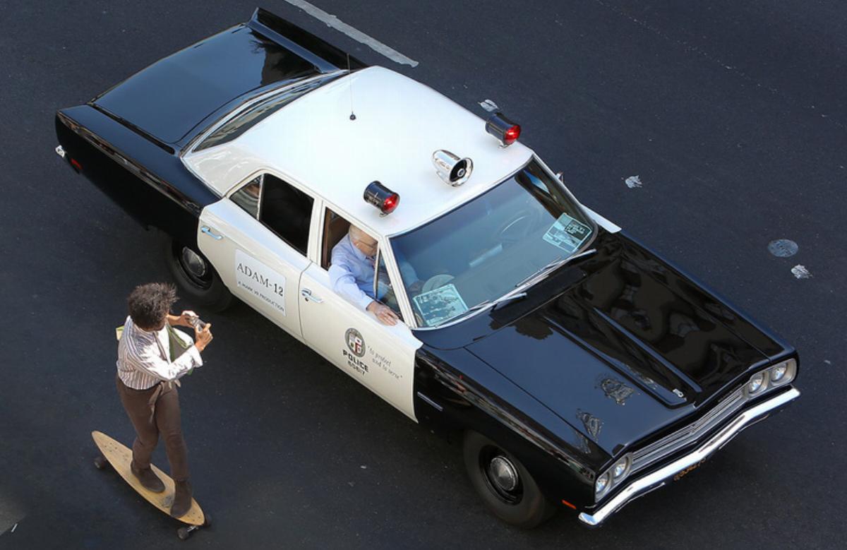 A skateboarder photographs a 1972 AMC Matador vehicle as it travels along Hollywood Blvd. in Hollyw A skateboarder photographs a 1972 AMC Matador vehicle as it travels along Hollywood Blvd. in Hollyw