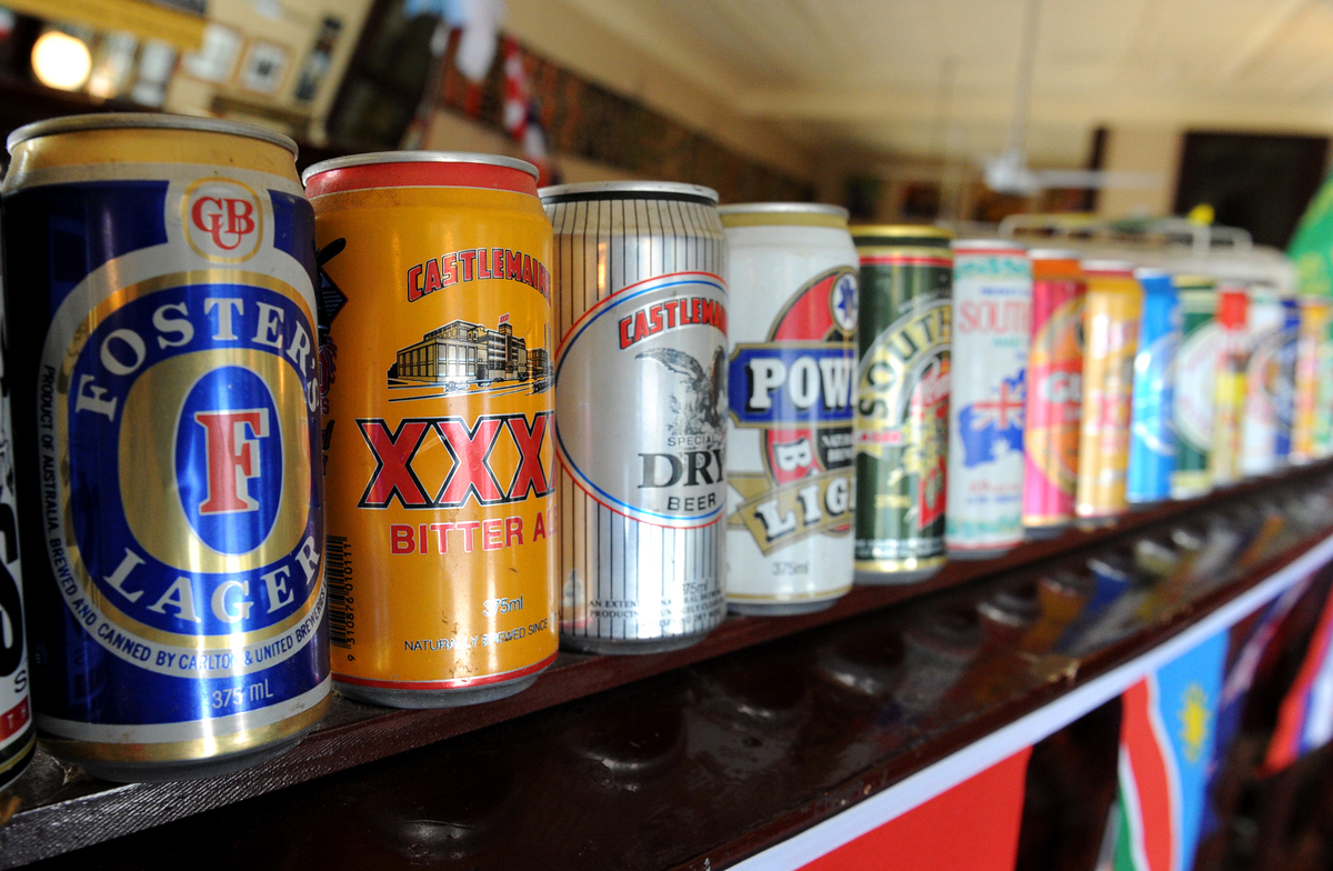 An empty can of Foster's Lager  adorns the wall next to cans of other beers