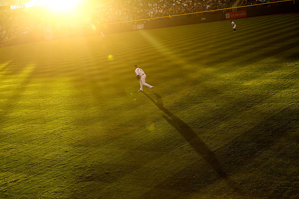 The evening sun glows as right fielder Carlos Gonzalez #5 of the Colorado Rockies