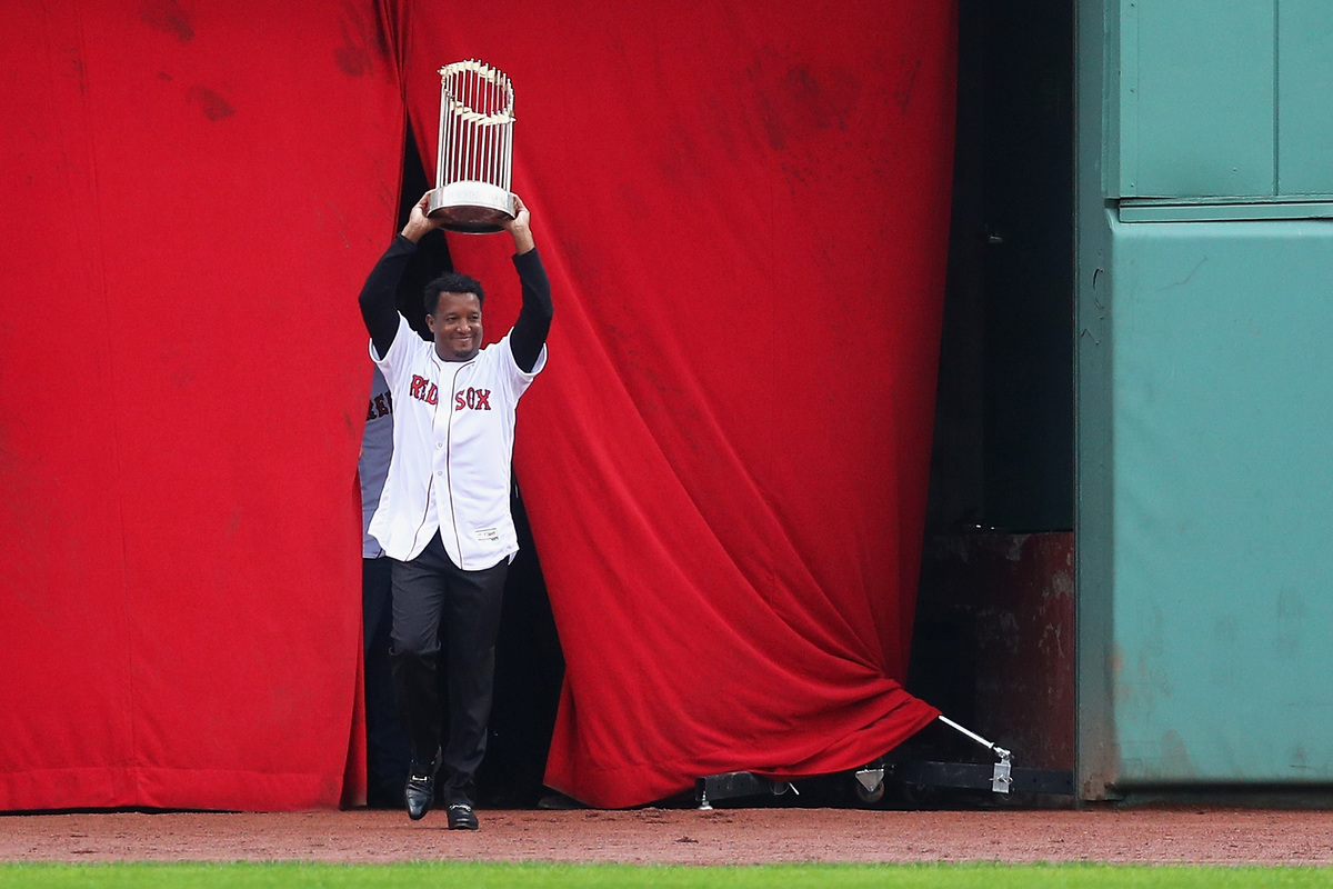 Pedro Martinez enters the field carrying the 2004 World Series Championship trophy