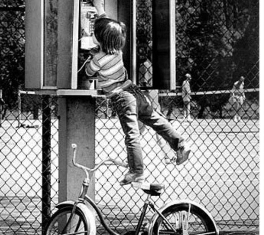 kid hanging from telephone
