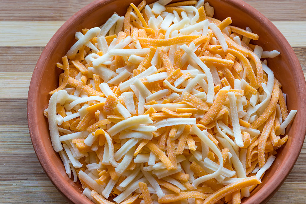 a bowl of orange and white shredded cheese