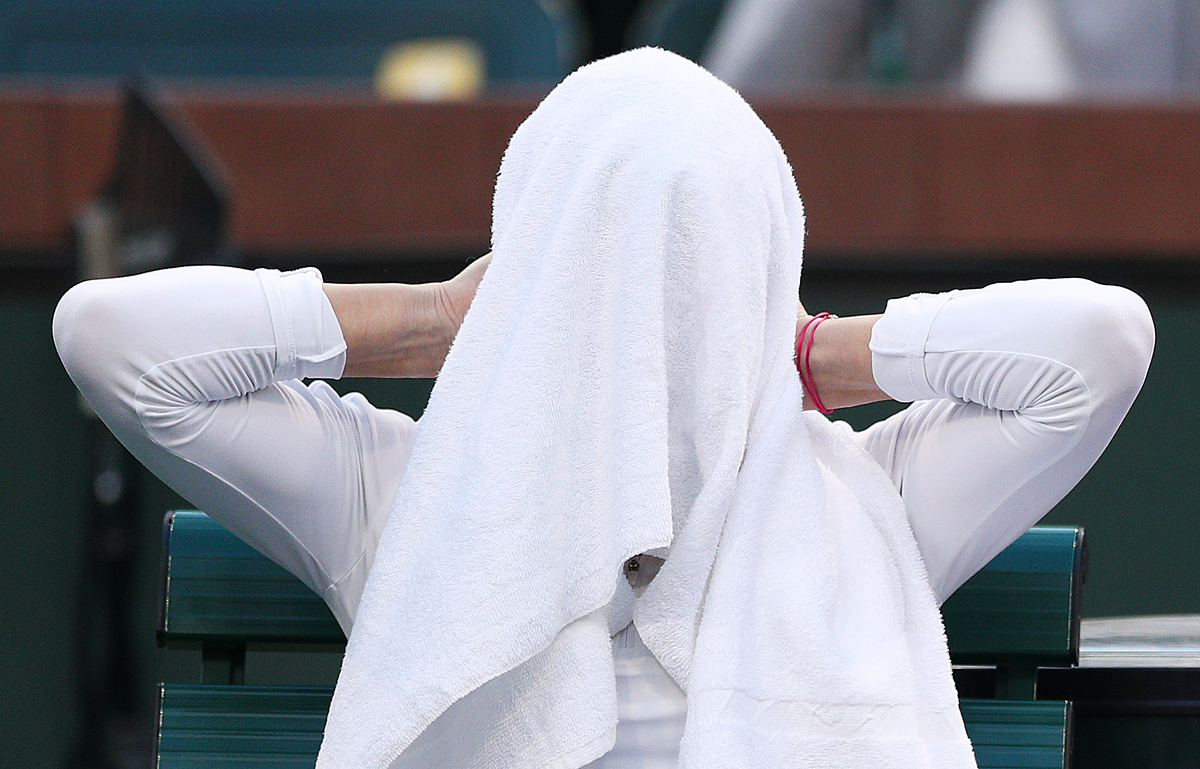 Simona Halep of Romania covers her face with a towel