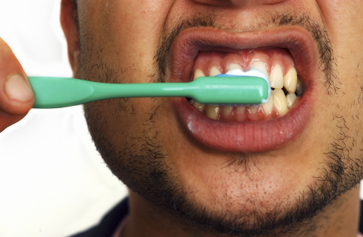 Close-up of young man brushing his teeth