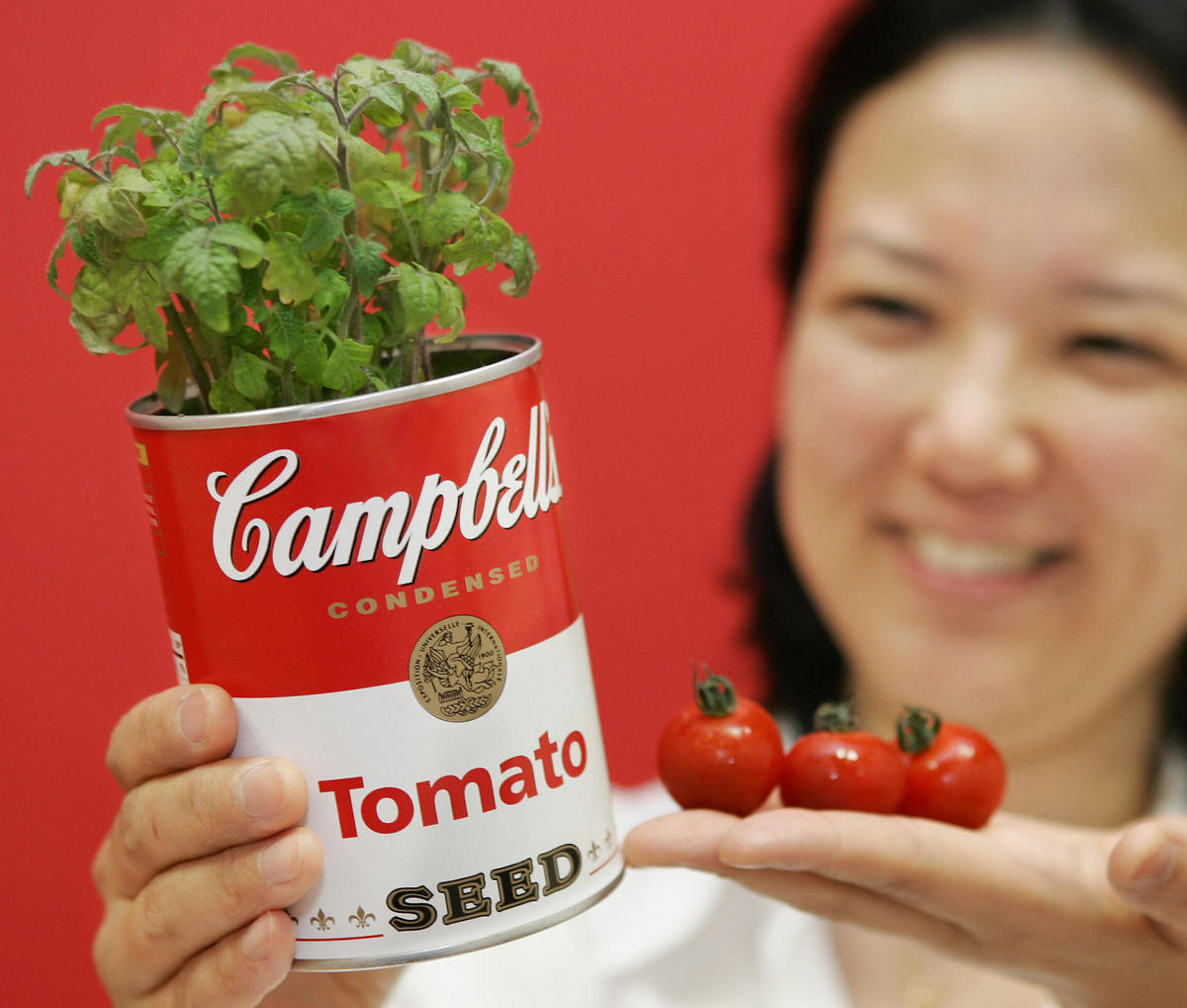 A Japanese woman displays a canned plant shaped like a Campbell's soup can, 