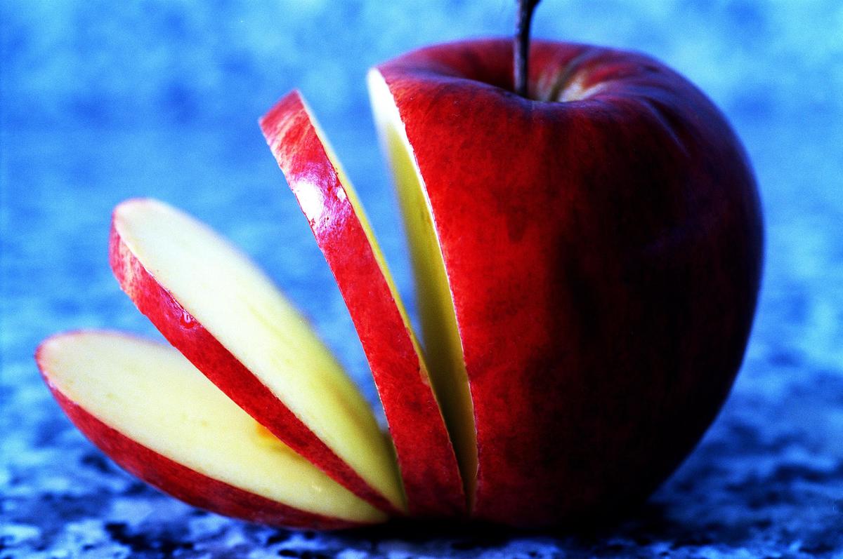 A sliced apple sits neatly on a blue surface