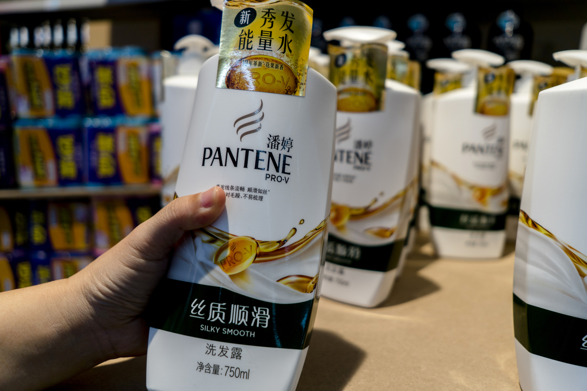 Customer chooses a Pantene shampoo in a supermarket.