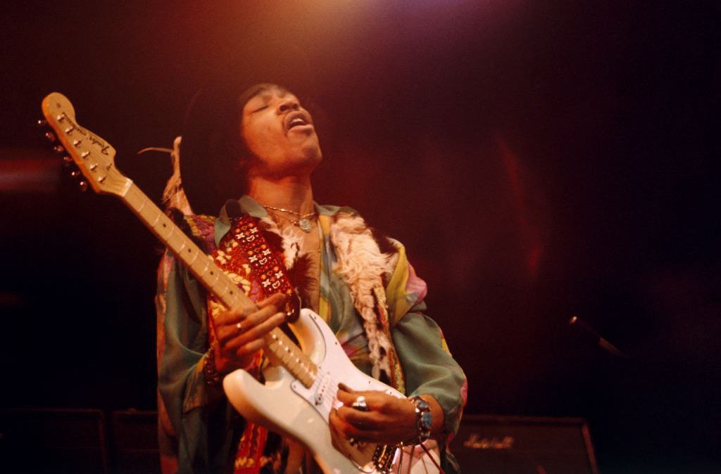 Jimi Hendrix playing on stage 