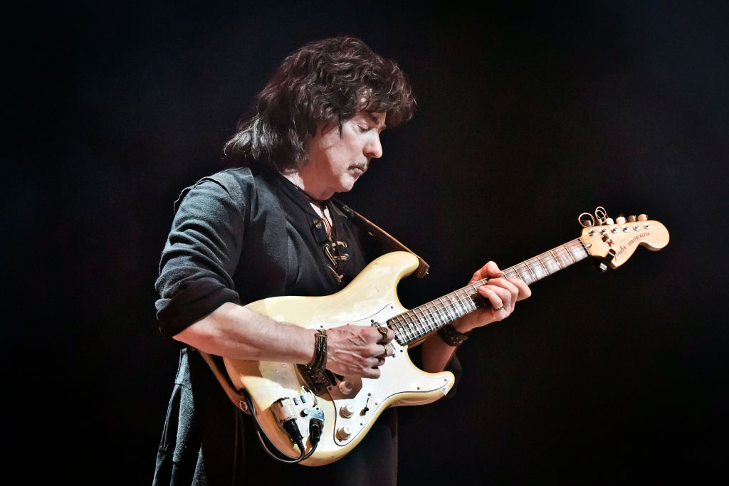 Playing guitar in all black 