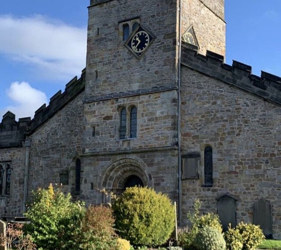 a clock off centre covering a window on a tower