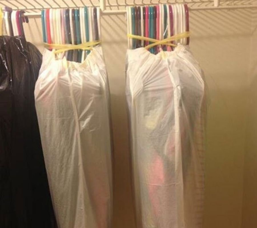 groups of hangers covered and held together by garbage bags 