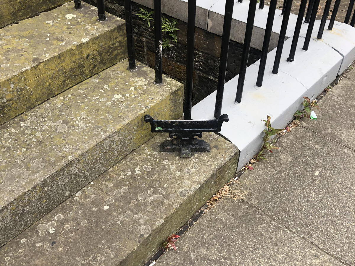 A metal boot scraper sits on the stairs of an Edinburgh home.