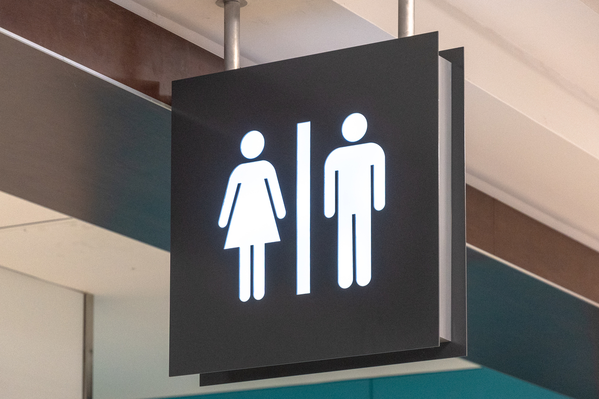 Public washroom or bathroom sign hanging from the ceiling of Pearson International Airport. 
