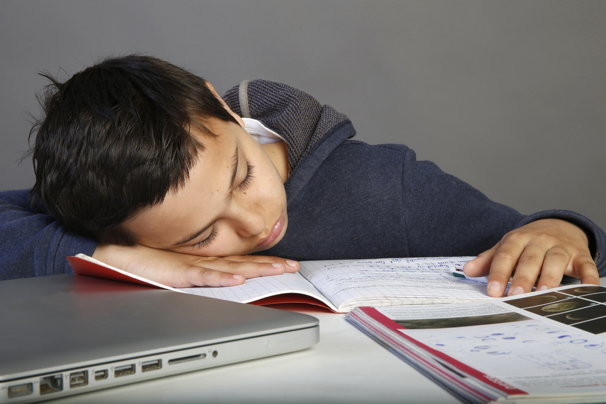 12-year-old schoolboy falls asleep on his homework.