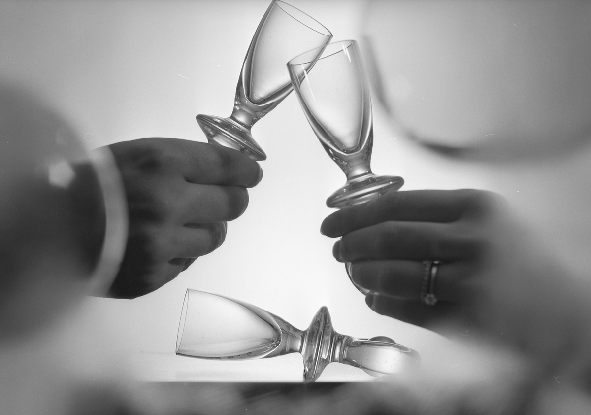 People cheer with tiny, empty wine glasses in 1970.