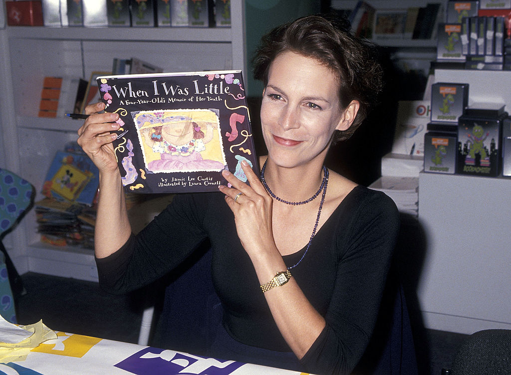 Jamie smiles while holding up her first published children's story.