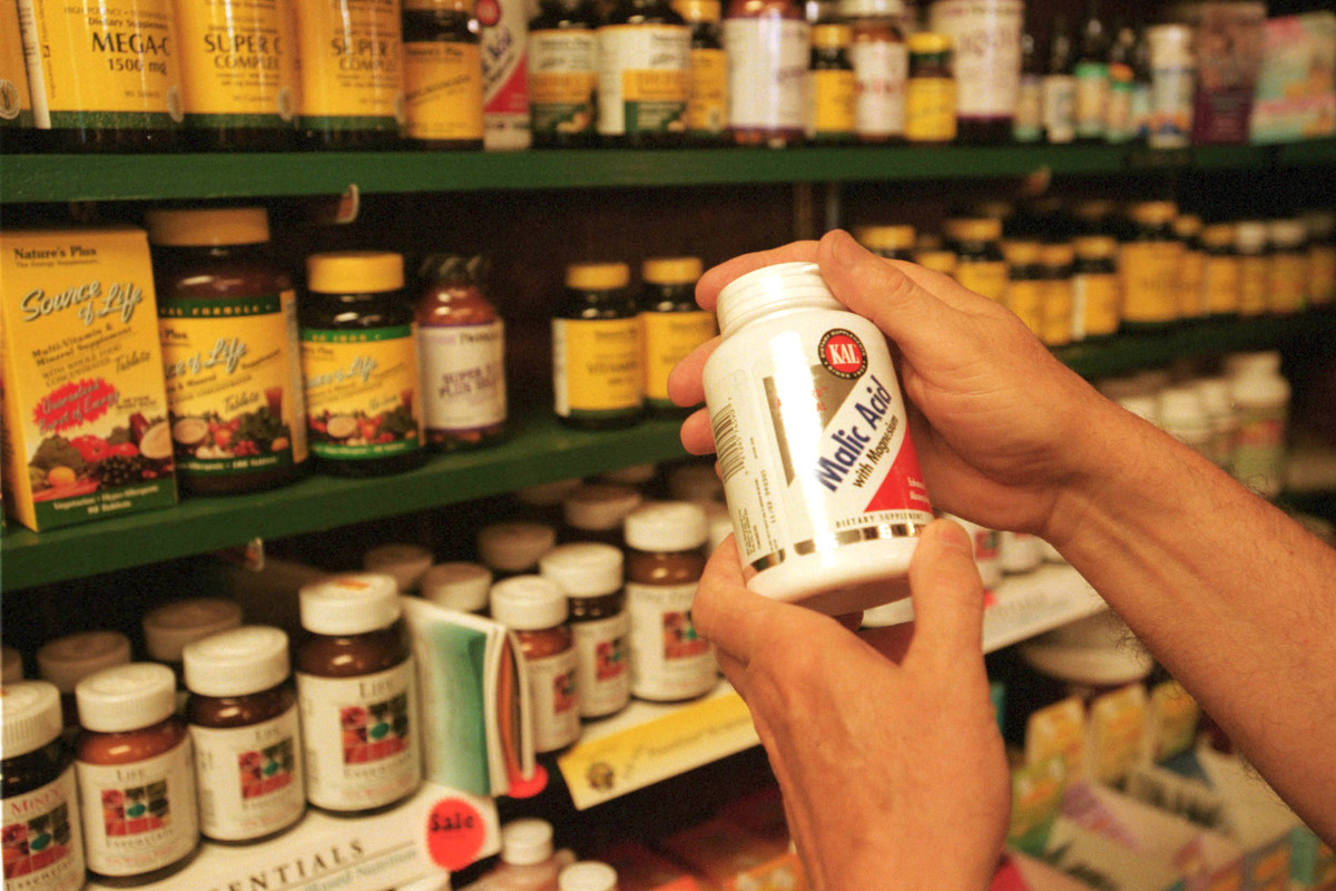 A customer looks at vitamins in a store.