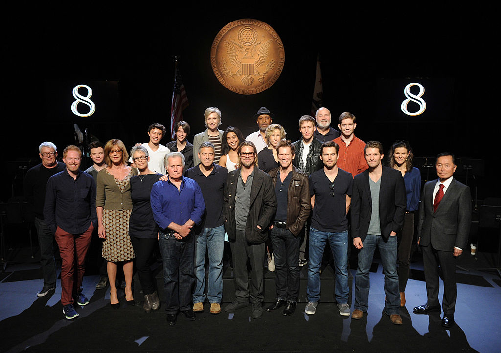The cast of 8 take a group photo onstage.