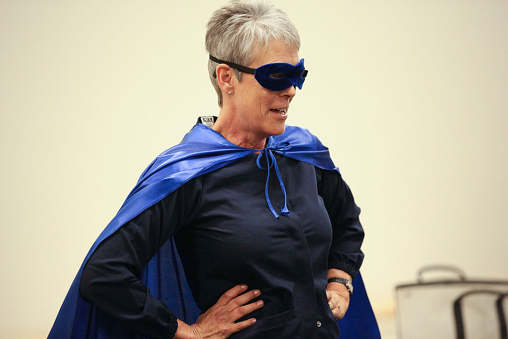 Jamie wears a cape and mask at a luncheon.