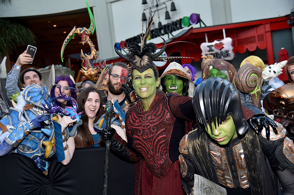 Dressed in cosplay, Jamie and her son pose with a crowd for a photo.
