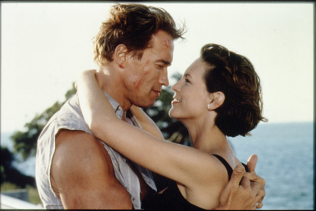 Arnold Schwarzeneggar and Jamie Lee Curtis embrace while filming True Lies.