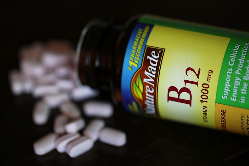 B12 vitamins - 866755524 A spilled bottle of vitamins B12 pills is displayed.
