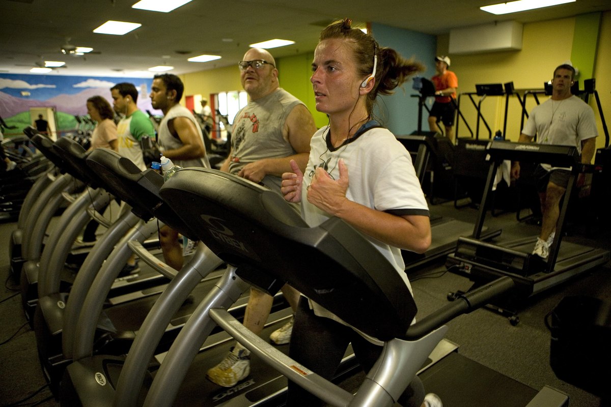 Members of Gold's Gym work out on treadmills.