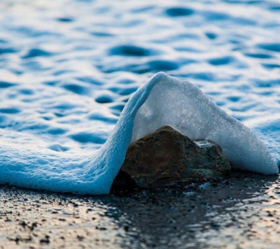 waves a wave coming over a stone
