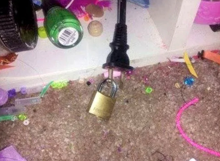 Parent puts lock through hole in electrical plug