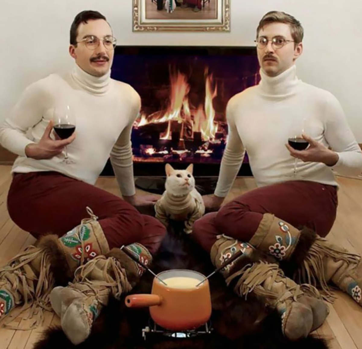 fondue two guys in matching outfits (their cat has the same sweater too) with apot of fondue