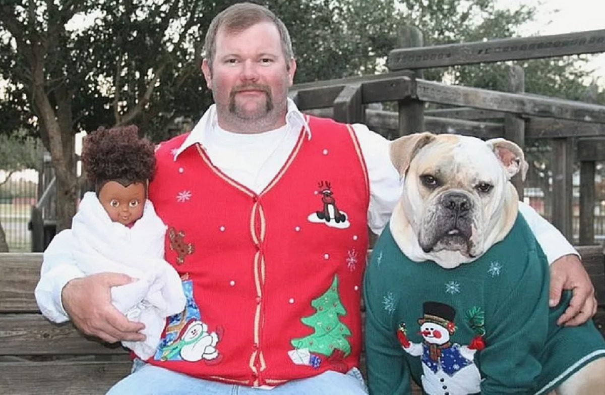 dog and baby man in christmas vest with dog and baby doll