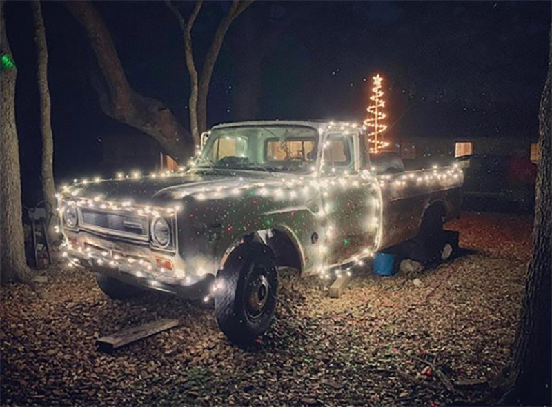 A truck is covered with Christmas lights.