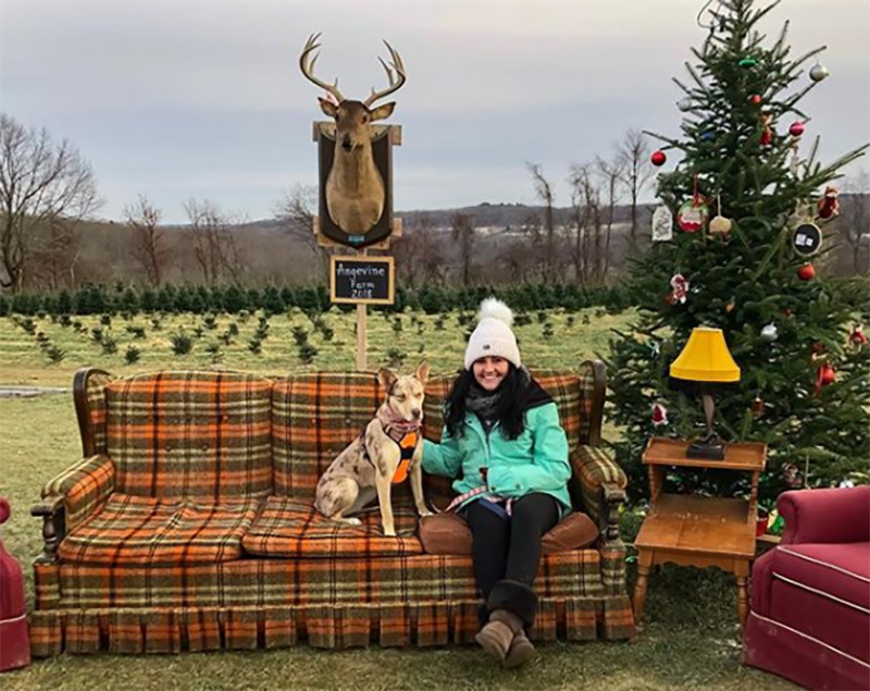 A woman and her dog sit in an outdoor living room.