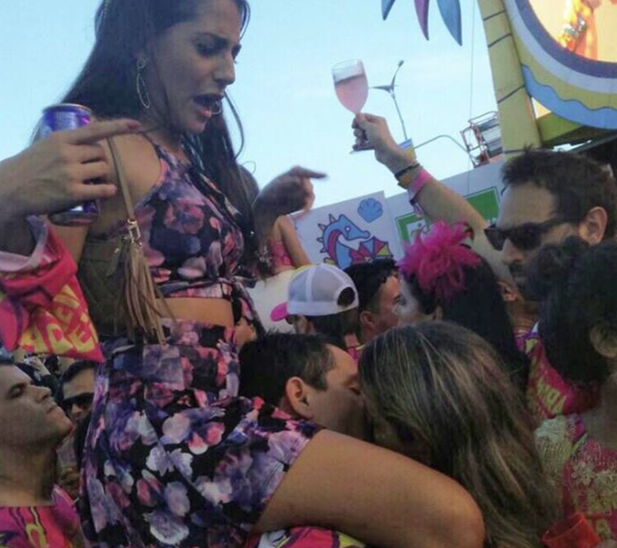 a guy kissing a girl while his girlfriend is on his shoulders