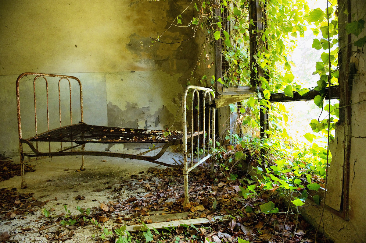 A bed frame remains in one of the dormitories in the psychiatric ward of the abandoned Hospital of Poveglia.