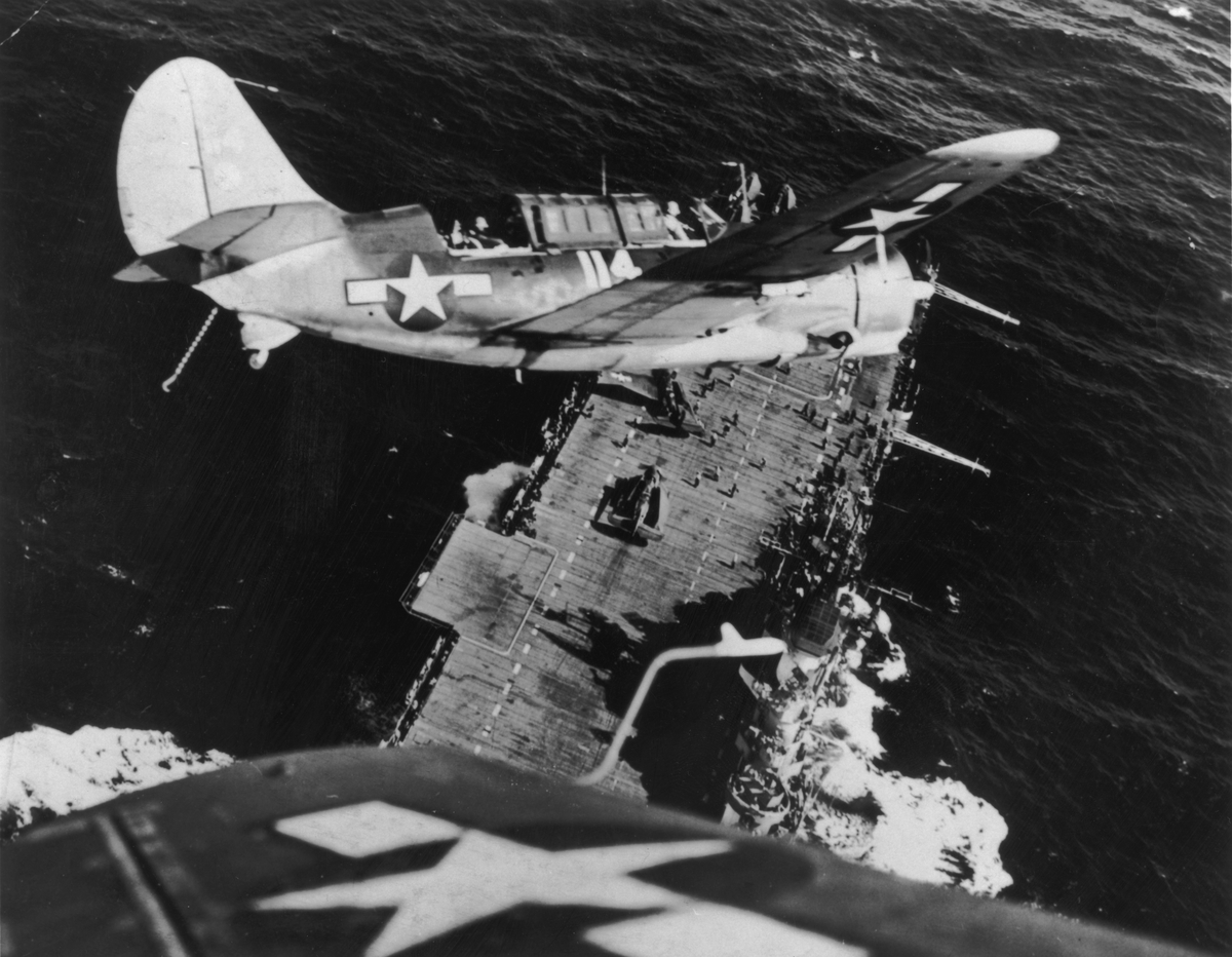 A US Navy Curtiss Helldiver (SB2C) prepares for a landing on an aircraft carrier after mission against a Japanese warship.