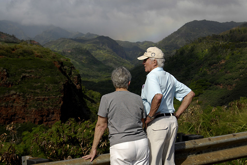 couple-in-hawaii A couple overlooks a hillside.