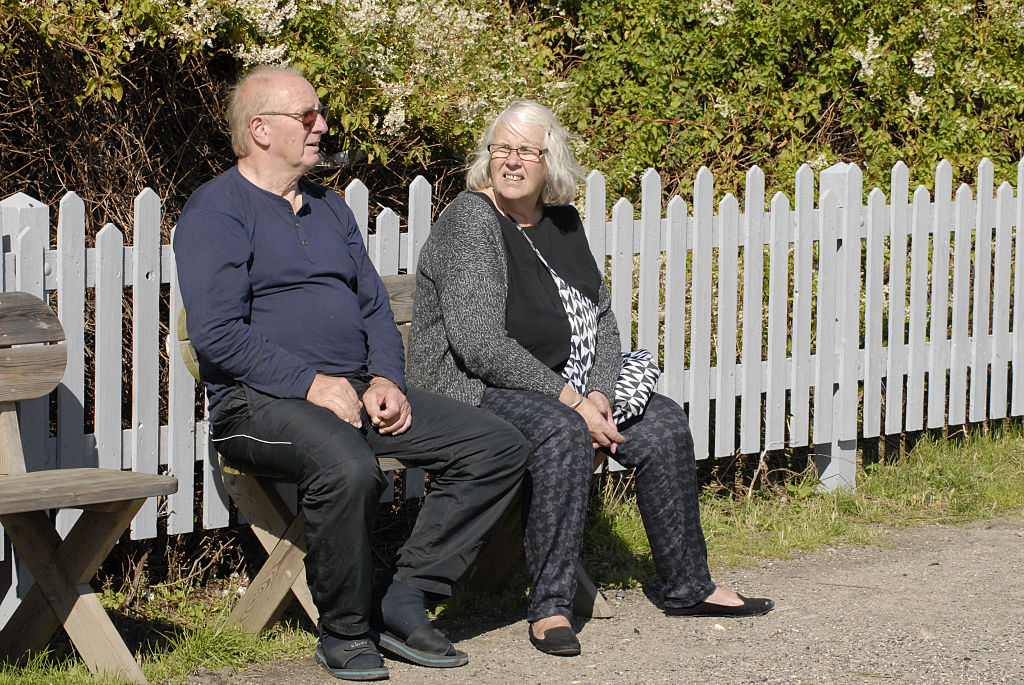 old-couple An older couple sits on a bench.