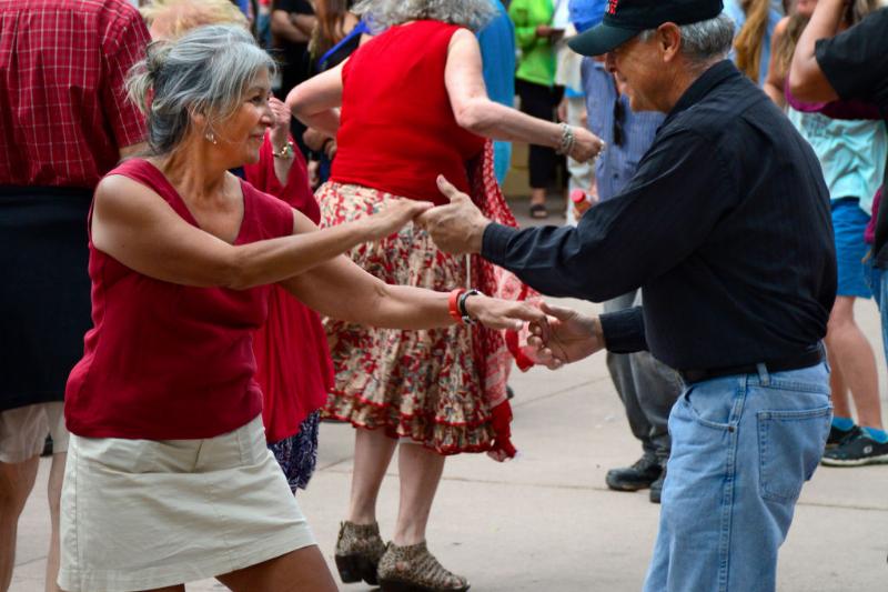 dancing-retired-couple A retired couple dancing outside amongst a crowd.