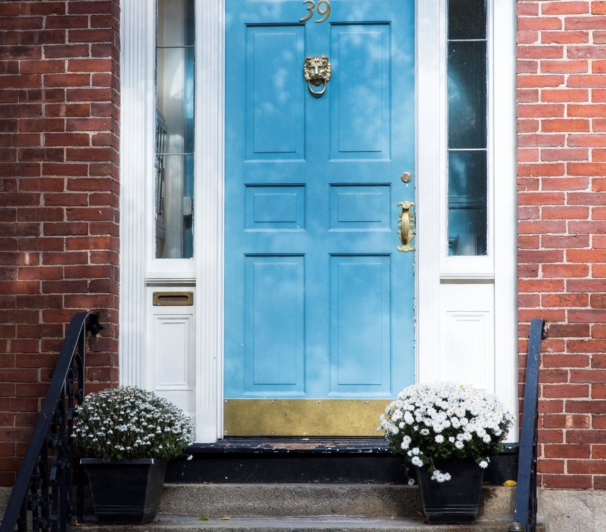 potted-plants-at-front-door Two potted plants sit on either side of a front door.